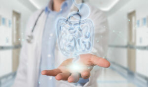 Ein Arzt hält in einem Krankenhausflur ein digitales Hologramm eines menschlichen Verdauungssystems.