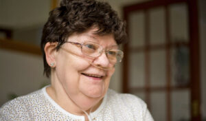 Nahaufnahme einer lächelnden Frau mit einer Nasenbrille