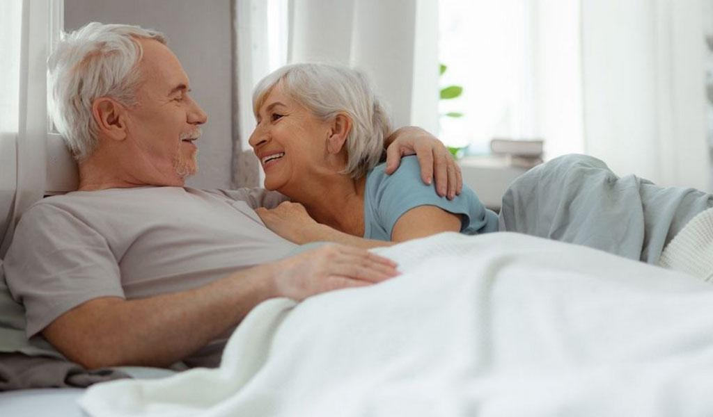 Älteres Paar kuschelt im Bett